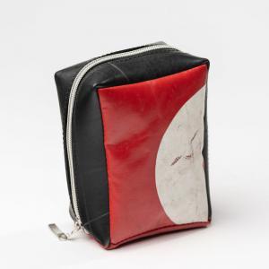 Eine kleine rechteckige Tasche aus rot weiß schwarzen Planen genäht