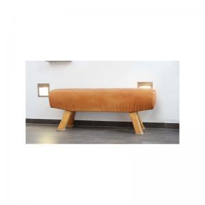 Ein Turnpferd mit Leder und gekürzten Holzbeinen dient als Sitzbank in einem gefliesten Raum